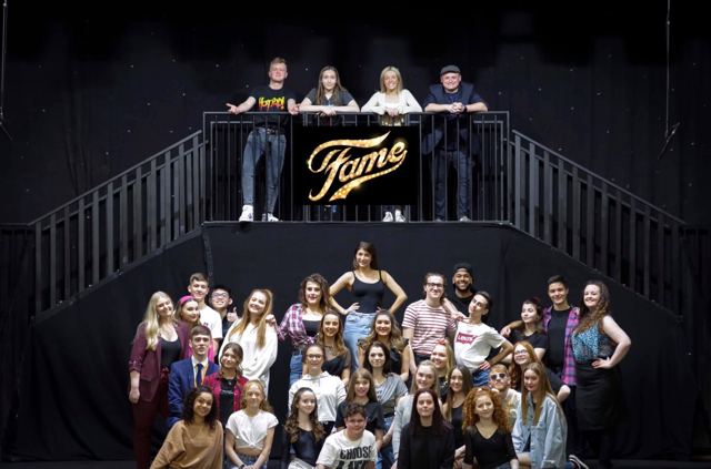 The cast posed on the set under the Fame sign