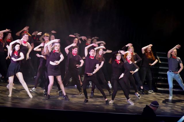 Dancers in black and red mid-routine