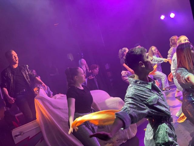 Performers dancing under purple light