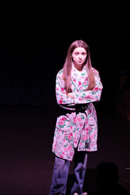 A young woman in a floral dressing gown standing alone