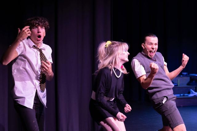 Three performers reacting in surprise