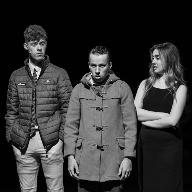 Black-and-white portrait of three performers
