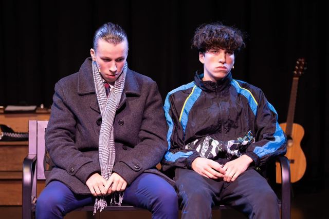 Two young men sitting side by side on a bench