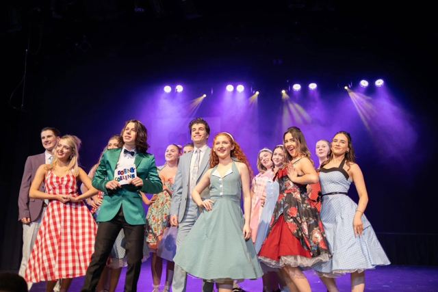 The company performing a number under purple lights
