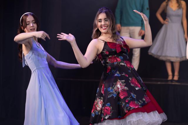 Two performers in long dresses dancing