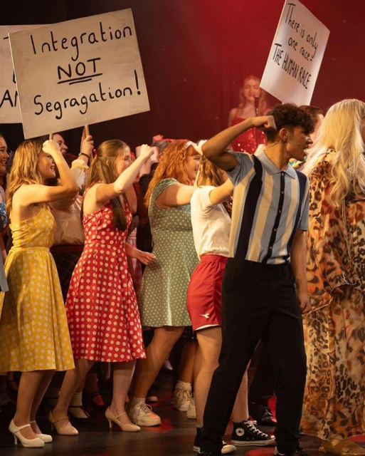 Performers marching with placards reading "Integration not segregation"