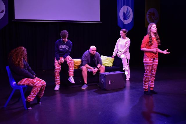 A wide view of the stage with five performers