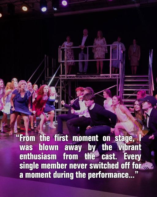 The company dancing, with a review quote